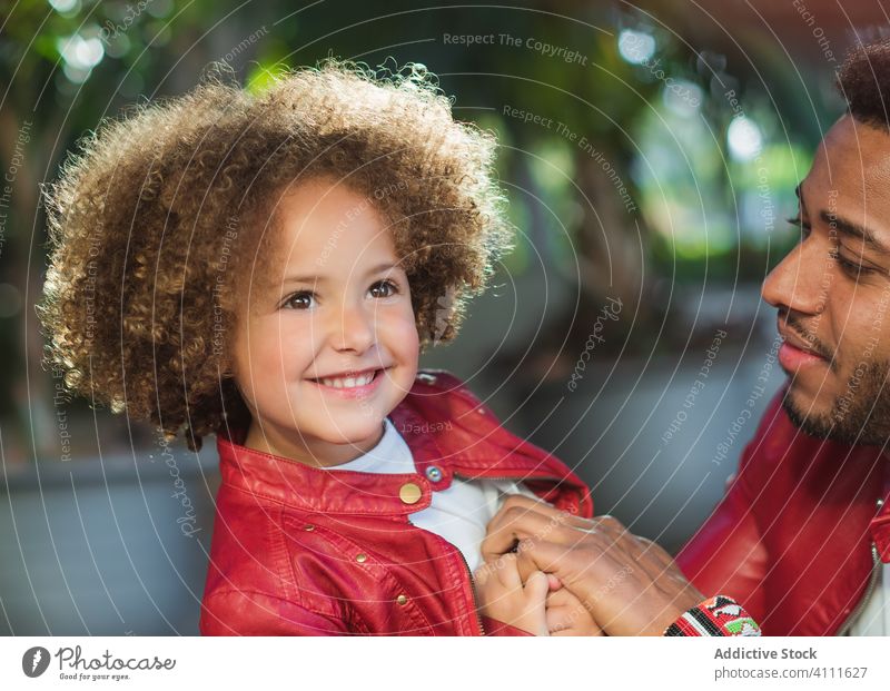Happy little girl with dad in park father daughter together happy smile street love similar urban kid man ethnic child relationship cheerful joy kiss alike