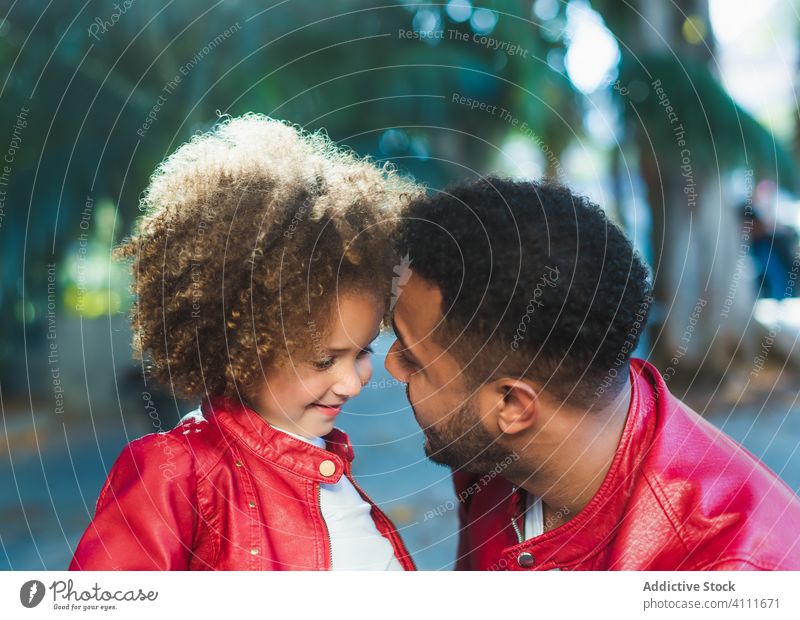 Happy little girl hugging dad in park father daughter together happy smile street love similar urban kid man ethnic child relationship cheerful joy kiss alike