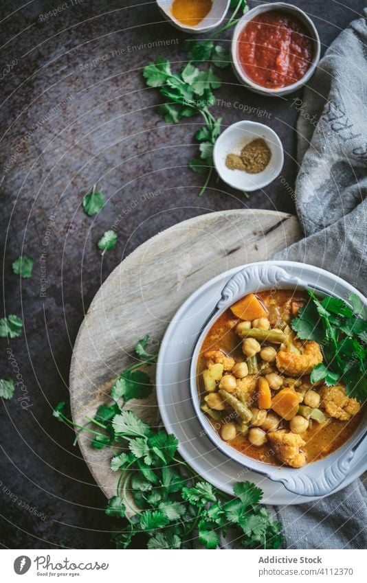 Bowl with vegetarian chickpea curry vegan bowl table napkin herb dish food meal delicious tasty fresh cuisine gourmet tradition soup dinner lunch healthy