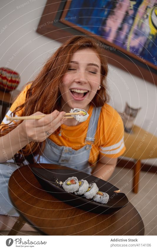 Young female eating sushi at home woman chopstick japanese young table casual food ginger seafood fish rice plate roll asian oriental dinner lunch fresh meal