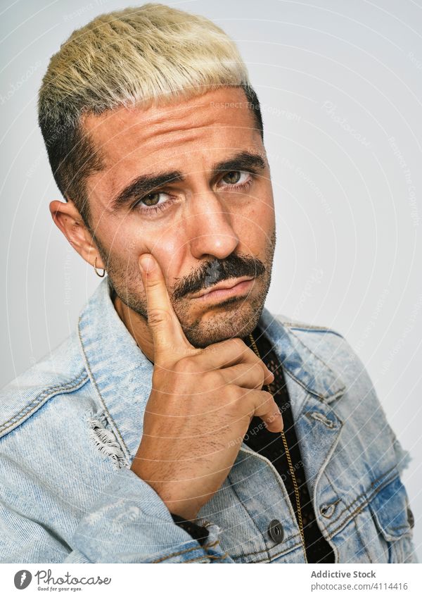 Stylish grimacing man in denim outfit trendy independent expressive grimace style modern hipster ethnic male jacket mustache confident fashion contemporary