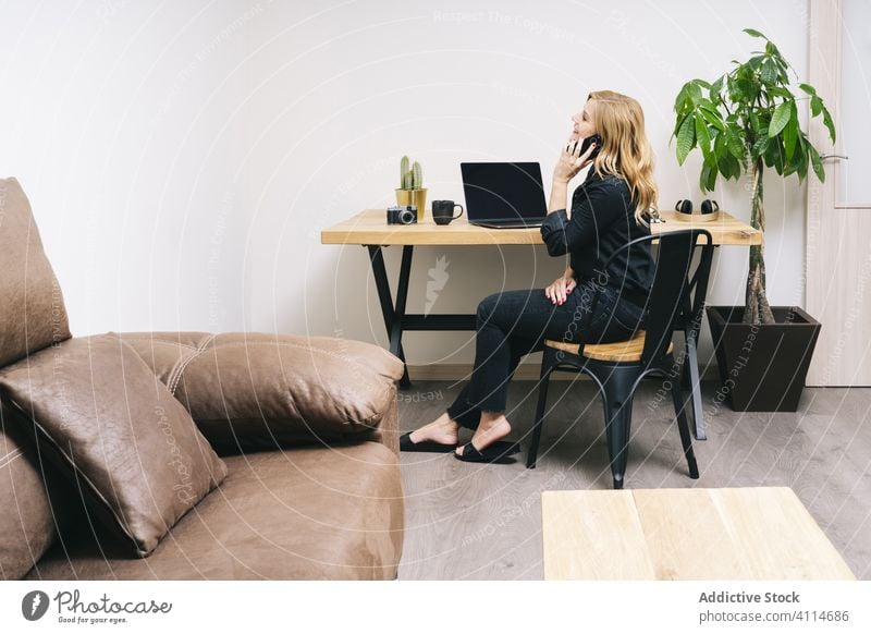 Woman working from her studio office at home woman talking desk computer business adult eyeglasses laptop caucasian browsing typing businesswoman internet