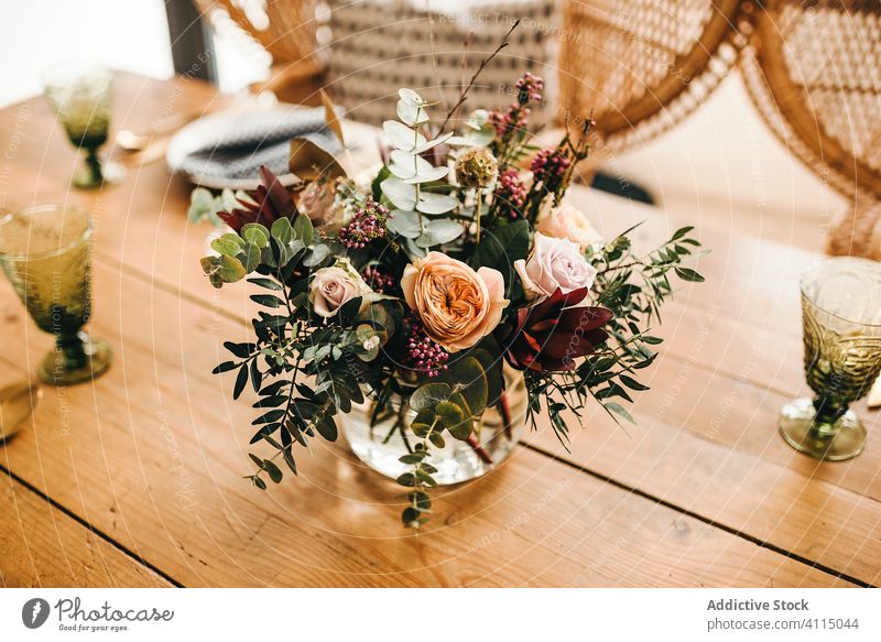 Flowers and plant twigs on a vase decorating a wooden table flowers bunch leaf bouquet water petal concept glass fresh bloom interior vintage nature decorative