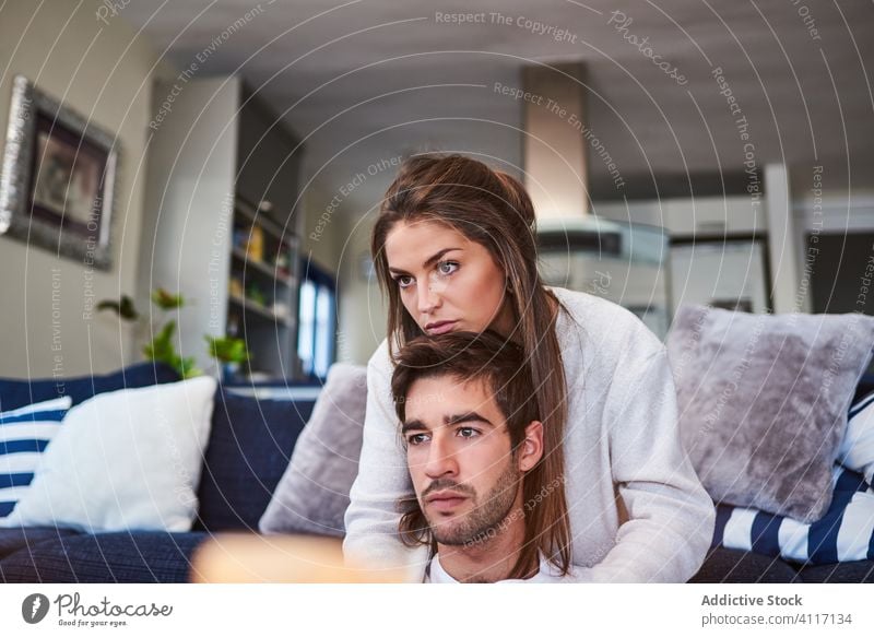 Young couple in love resting together at home hug relationship romantic casual sofa relax young positive happy cozy embrace smile lifestyle affection