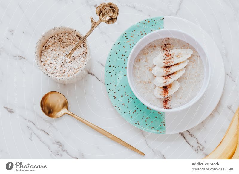 Oatmeal porridge with banana and cinnamon oatmeal breakfast healthy table spoon marble bowl plate fresh delicious fruit nutrition sweet cereal natural dessert