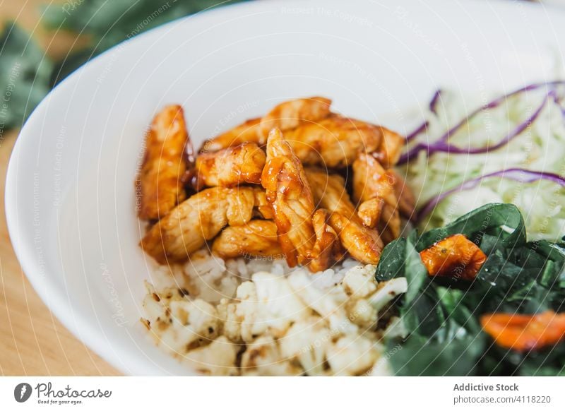 Fried chicken with vegetables and sauce salad silverware grain arugula tomato cabbage yummy plate wooden meat food kitchen knife fork utensil home fried roast