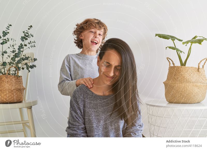Happy kid with mother playing at home cheerful together having fun laugh playful happy enjoy relationship cozy woman boy son casual love cute lifestyle glad