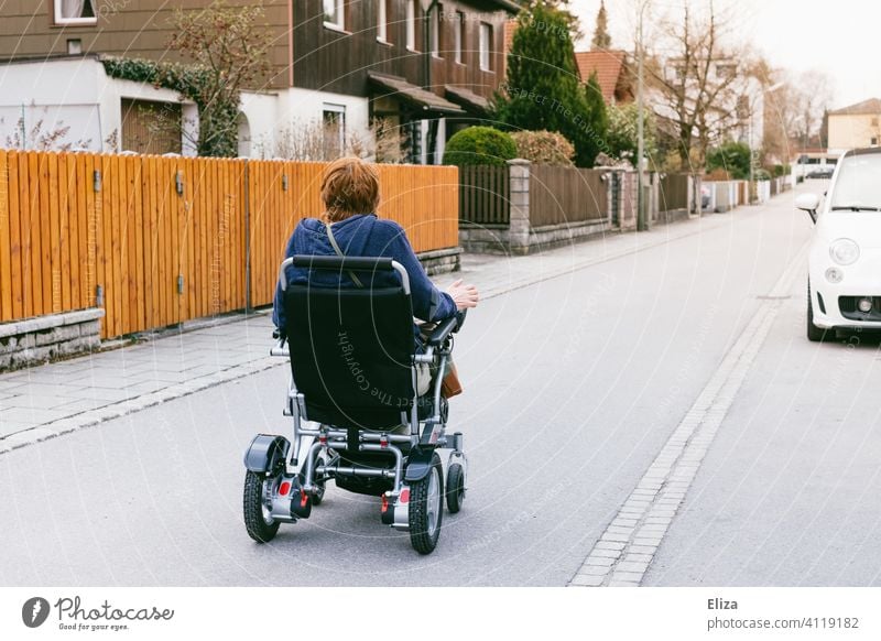 Woman riding an electric wheelchair on the street. People with disabilities and mobility. power wheelchair handicap Street Mobility Wheelchair Human being
