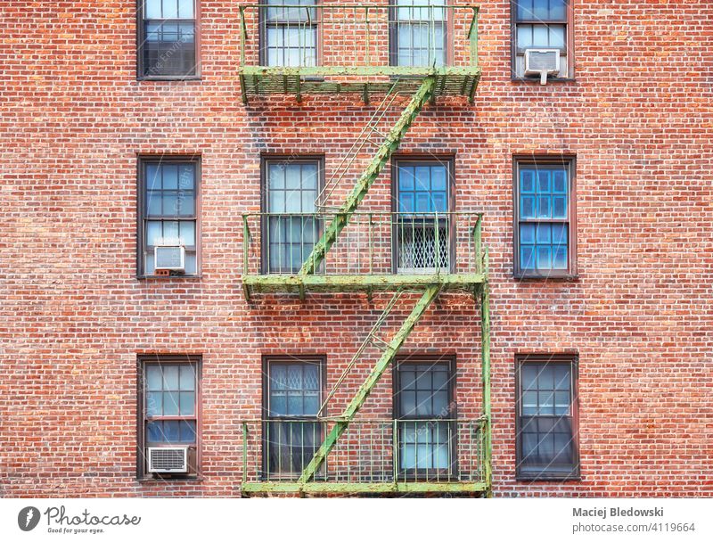Old brick building with green fire escape, New York City, USA. city Manhattan old townhouse architecture stairs apartment facade NYC ladder residential urban