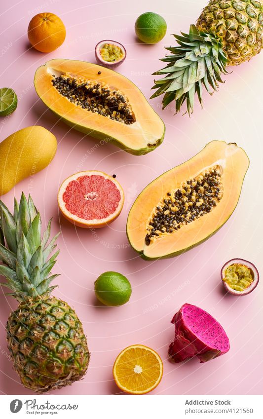 Top view creative layout with exotic summer fruits tropical papaya hawaii ingredients natural organic food pitaya dragon passion tropical fruits green colorful