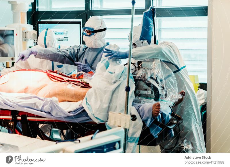 Doctors in protective uniform working in operating room in hospital doctor clinic viral patient care infection equipment treat specialist mask health care