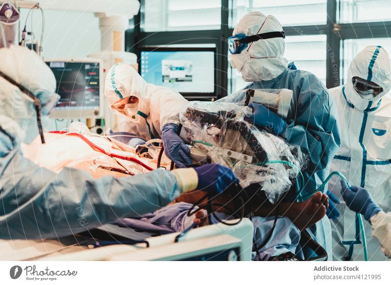 Doctors in protective uniform working in operating room in hospital doctor clinic viral patient care infection equipment treat specialist mask health care