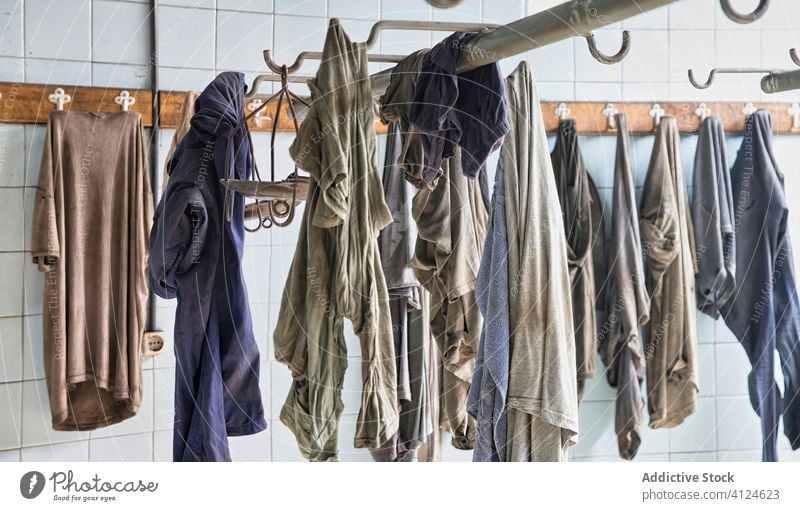 Locker room with dirty uniform on hangers locker messy cloth miner t shirt pants desert crumple rack abandoned coal industrial desolate daylight old empty