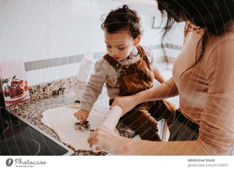 Cheerful little boy cooking pastry with mother in kitchen helper dough bonding cheerful food parent assistant smile together flour prepare child happy home