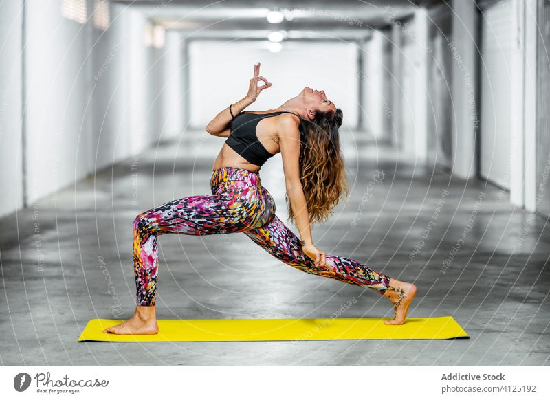Experienced woman practicing advanced yoga asana practice reverse warrior pose garage position challenge posture female wellness support lifestyle healthy fit