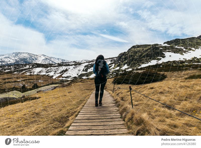 Woman hiker walking along the way to the snowy mountains. winter landscape hiking nature travel tourism adventure woman tourist backpack trail outdoor sky