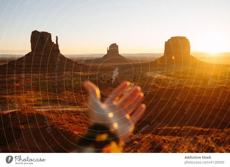 Stunning view of rocky terrain at sundown traveler sunset desert cliff nature landscape explore freedom hand journey tourism relax tourist wild idyllic peaceful