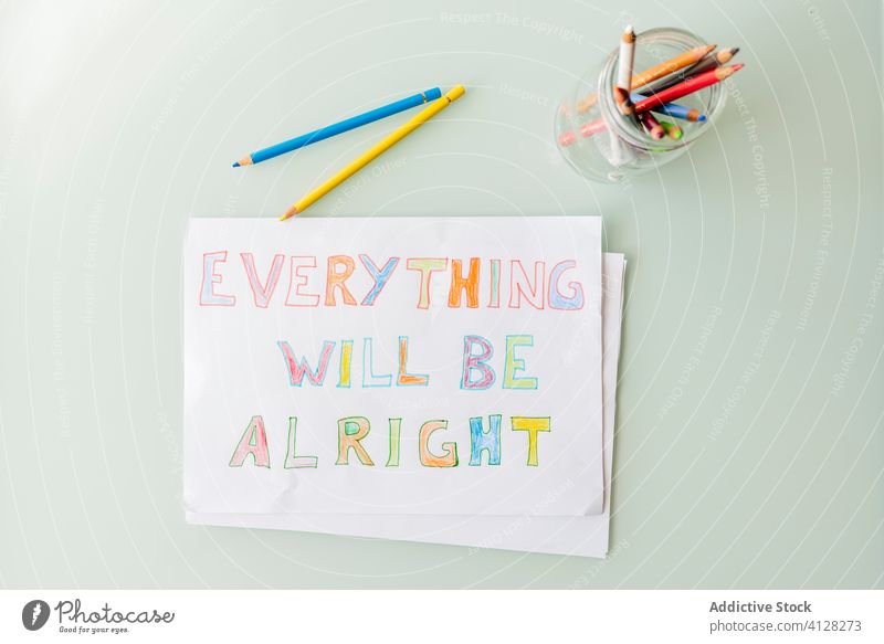 Set of multicolored pencils in glass cup and drawing placed on table inspiration motivation everything will be alright paper colorful jar creative art bright