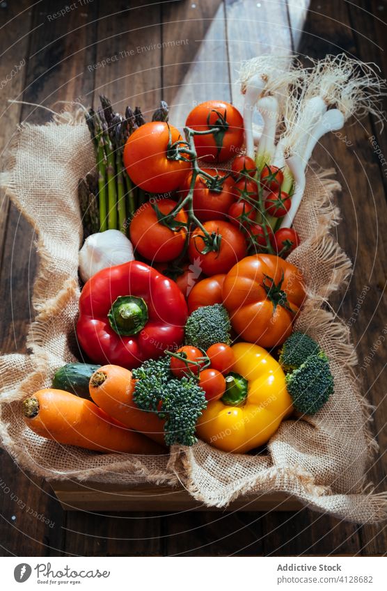 Wooden box with fresh multicolored vegetables and herbs on wooden rustic floor harvest assorted crate ripe food nutrition vitamin meal tomato carrot cucumber