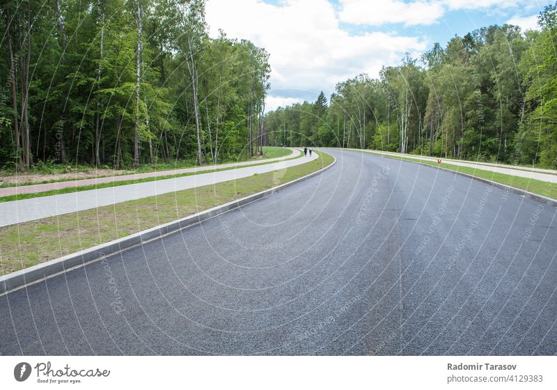 new modern road through the forest outdoor travel asphalt view highway nature transport landscape green line beautiful transportation speed sky summer traffic