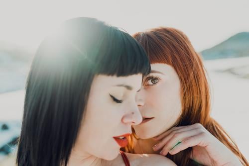 Couple of young women embracing in sunshine couple together embrace tender sensual charming girlfriend love affection relationship lesbian lgbt homosexual happy