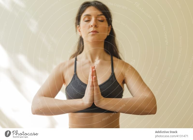 Tranquil woman meditating in Lotus pose lotus pose meditate yoga namaste padmasana mindfulness tranquil focus home female concentrate exercise mat training