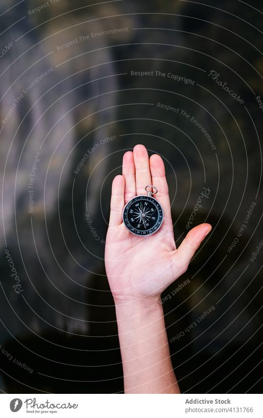 Crop traveler with metal compass tourist navigate orientate journey vacation direction location summer wanderlust explore destination adventure tourism water