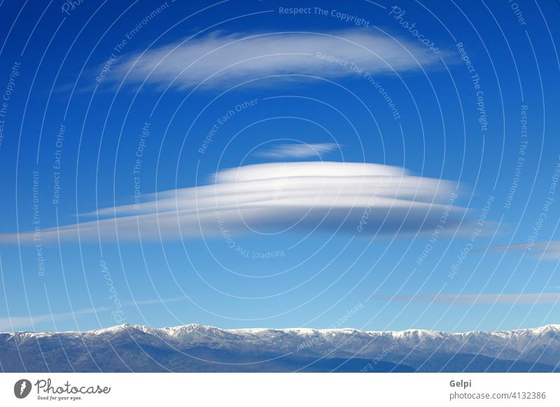 Big lenticularis cloud and snowed mountain altocumulus sky landscape peak clouds scenery wind spain unusual travel nature blue high altitude view meteorology