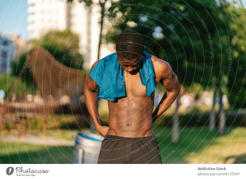 Athletic black man exercising at the park african shirtless muscular fitness strong flexing body muscle biceps athlete strength lifestyle chest athletic