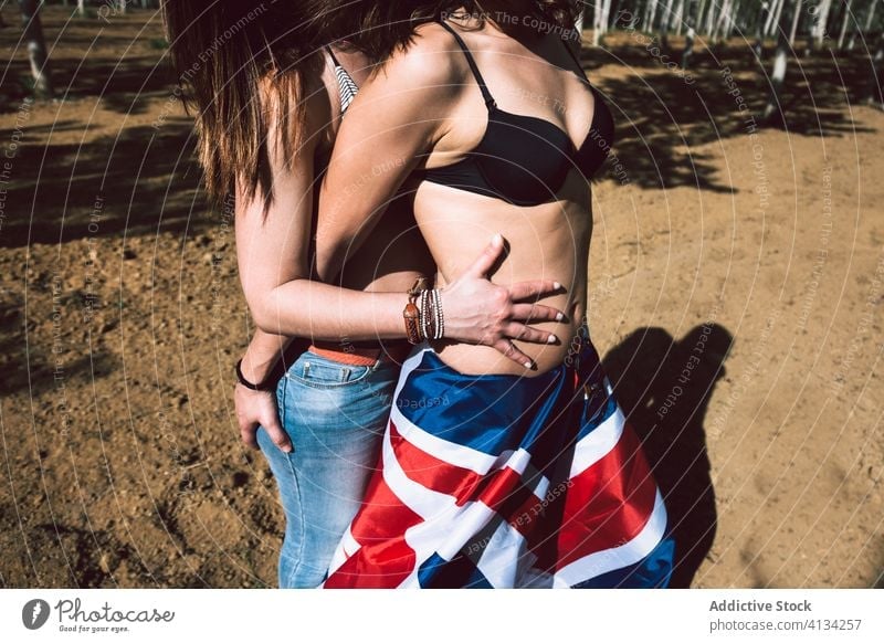Anonymous young couple of women kissing in park lesbian summertime hug underwear lover lingerie bra uk england gay great britain flag stand relationship lgbt