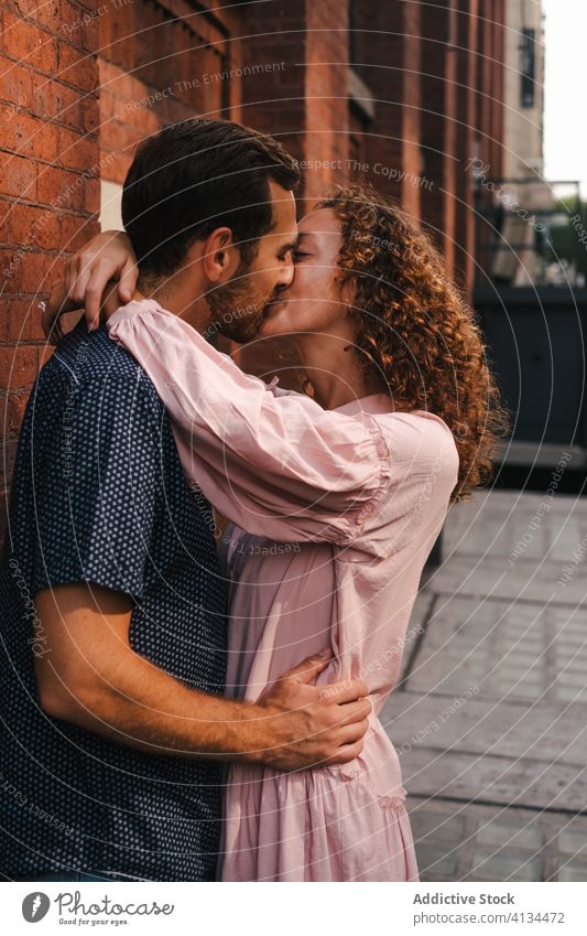 Smiling couple kissing on street - a Royalty Free Stock Photo from Photocase