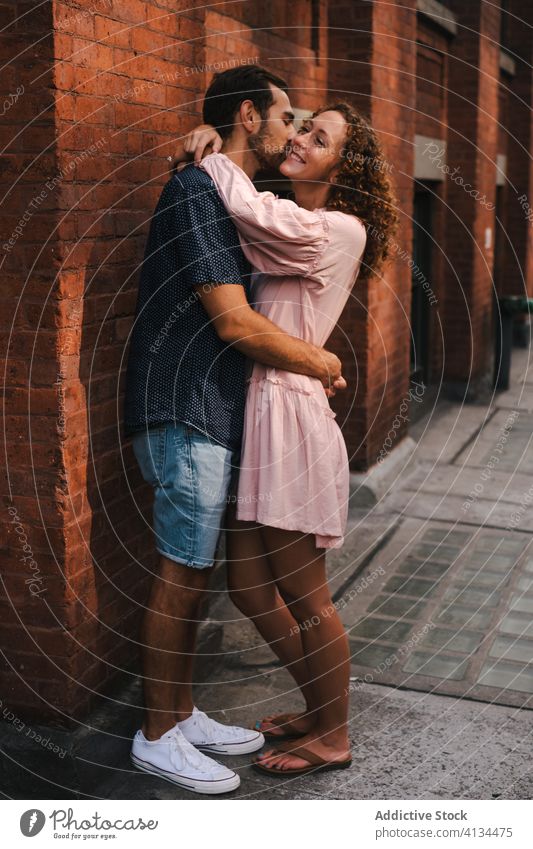 Smiling couple kissing on street love hug city relationship embrace together sunny romantic new york america united states usa building brick wall smile urban