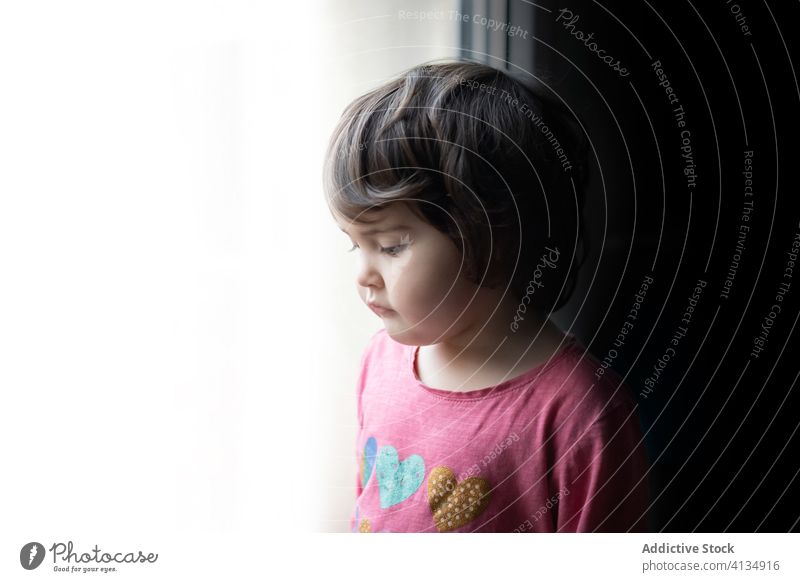 Sad kid standing near window home sad girl lonely unhappy thoughtful pensive calm child upset childhood tranquil solitude alone quarantine self isolation