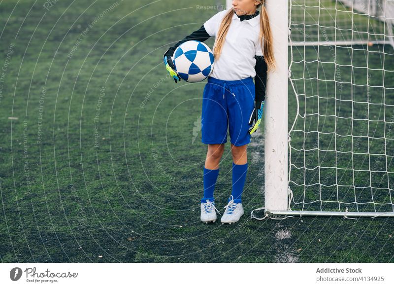 Crop young female player with ball in football arena at sports stadium girl soccer field uniform child kid club childhood athlete equipment preteen schoolgirl