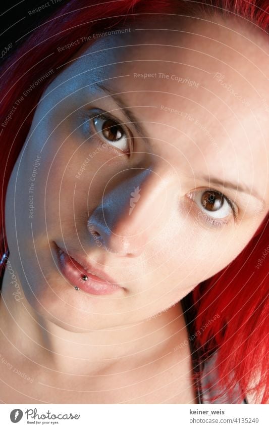 Face of young woman with piercing in lower lip and red hair Woman Piercing Lip piercing Young woman Skin jewellery brown eyes Red-haired Portrait format