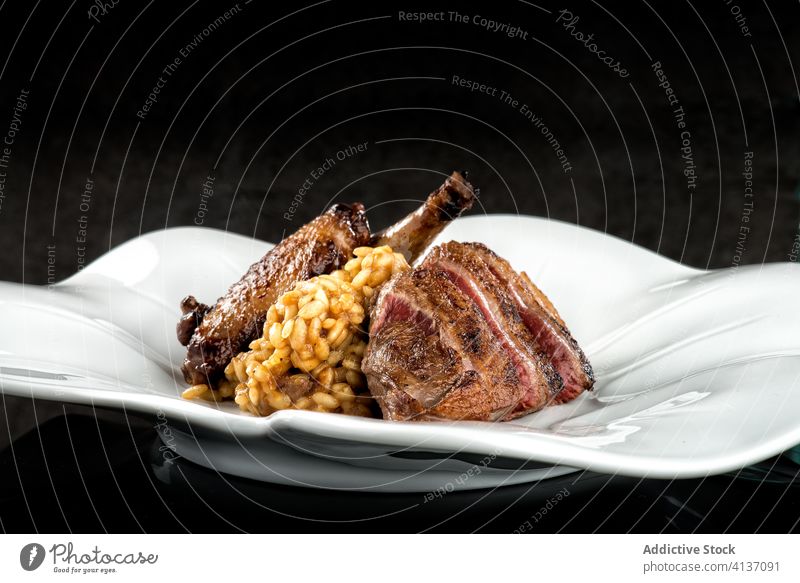 Appetizing risotto with roasted duck on plate meat rice meal food culinary grill protein cuisine dinner appetite dish italian bird lunch taste nutrition gourmet