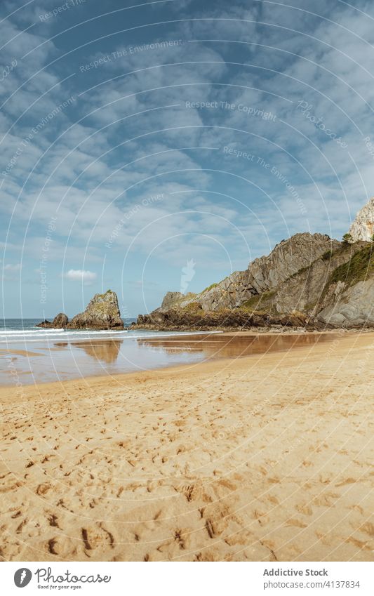 Sand sea beach near rock under cloudy sky sand footprint shoreline seascape picturesque peaceful spectacular harmony idyllic horizon reflection scenery nature