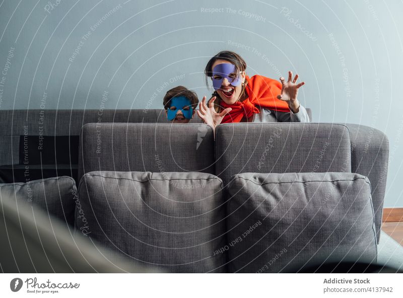 Creative mother and son in superhero masks at home play game creative pretend having fun playful cheerful little weekend boy kid child happy childhood joy