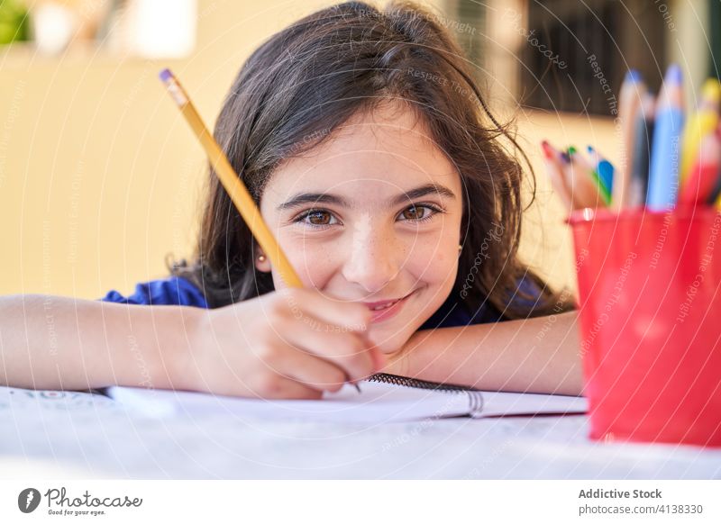 Little girl drawing with colorful pencils positive smile kid creative childhood hobby activity free time happy schoolgirl friendly little inspiration art sketch