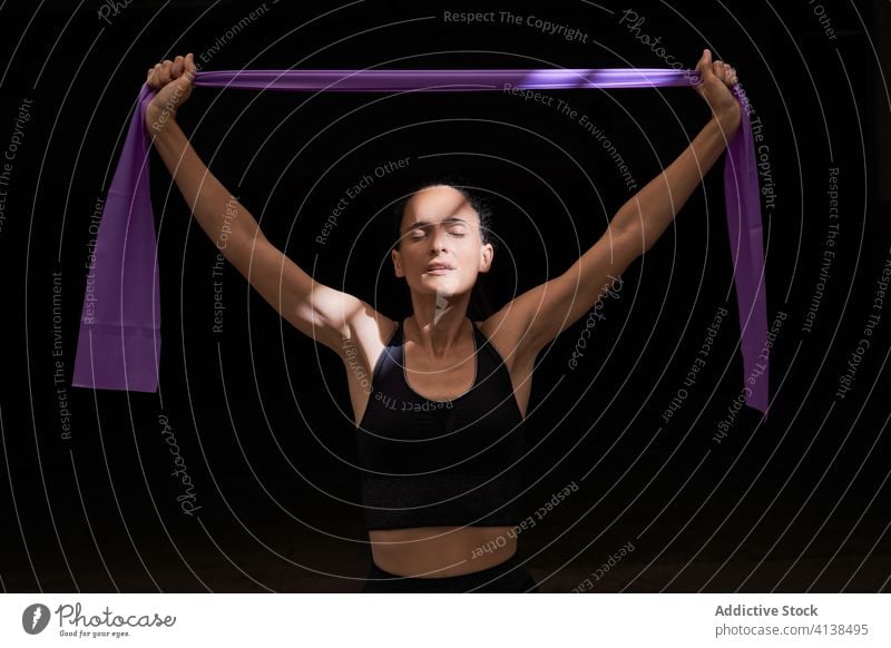 Portrait of Confident Sportswoman Stretching Elastic Band with