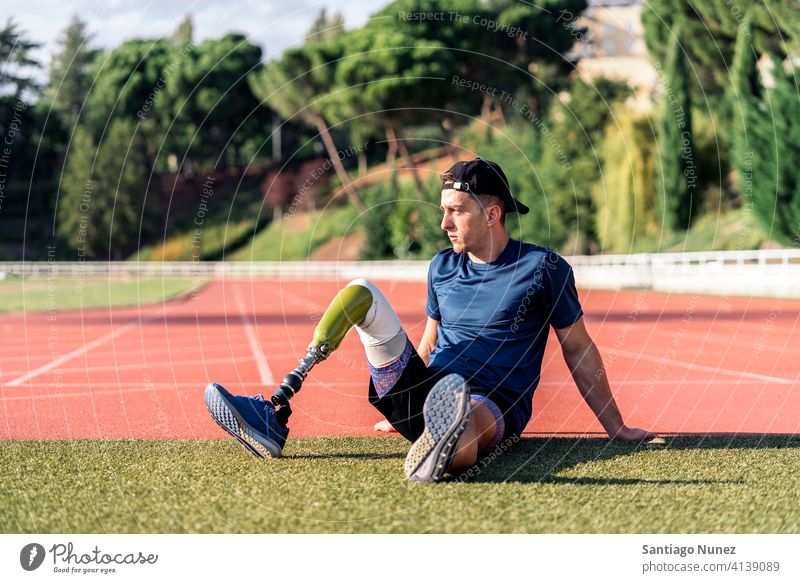 Disabled Man Athlete Resting portrait front view resting sitting stadium running track man runner athlete sport prosthesis prosthetic disability disabled
