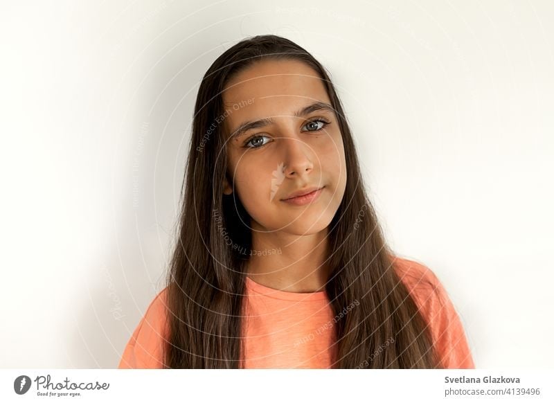 Portrait of a beautiful young teen hispanic girl with long brown health hair on white background. Calm face, beauty concept pretty happy female attractive latin