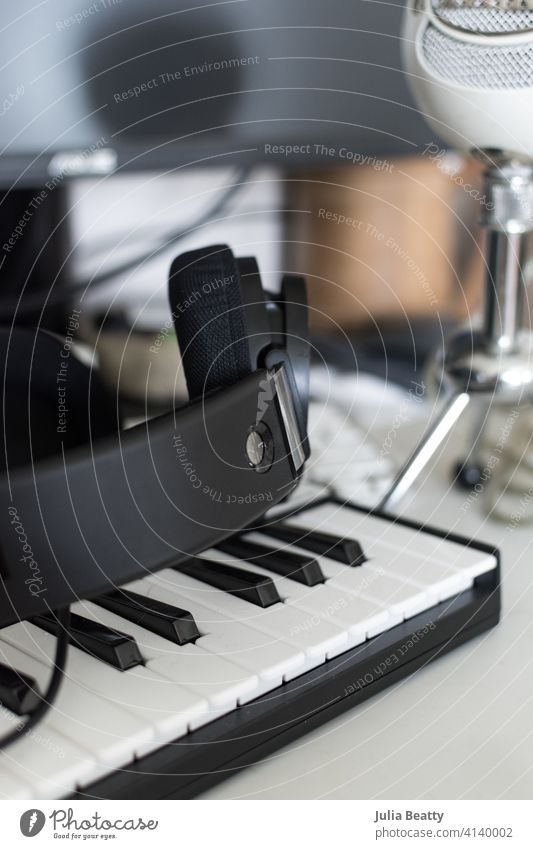 Musician's computer desk setup: keyboard, headphones, and microphone in front of a monitor music equipment dj audio technology sound studio office business