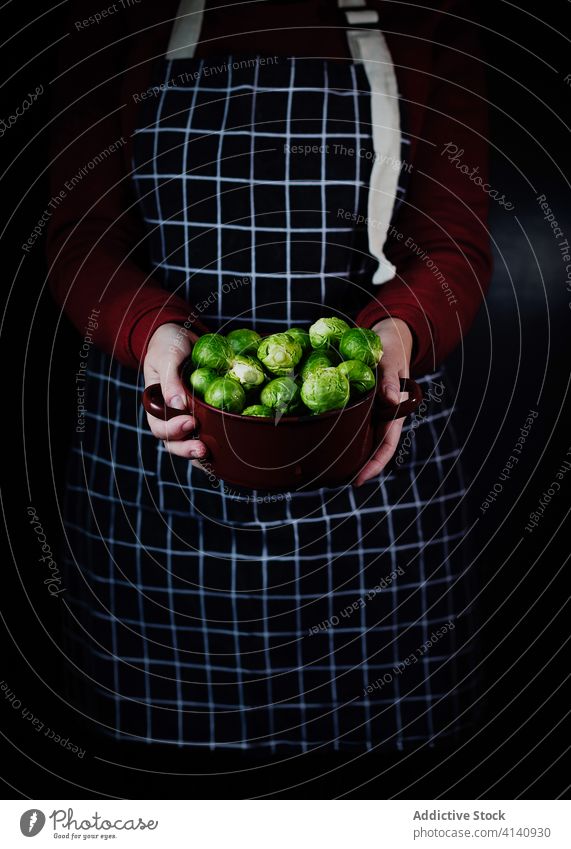 Crop woman with bowl of Brussels sprouts brussel sprout brussel cabbage cook apron fresh housewife kitchen female organic vegetarian ingredient healthy
