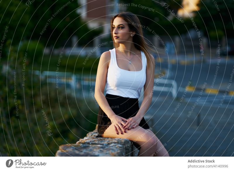 Calm ethnic woman enjoying sunset in city evening calm summer peaceful fence street female amazing sundown idyllic dusk stone sit relax tranquil lady serene