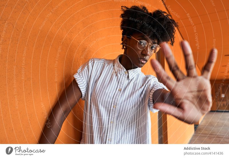 Serious black woman with hands raised protesting and trying to stop violence prevent against gesture sign dissuade objection concept renouncement refuse serious