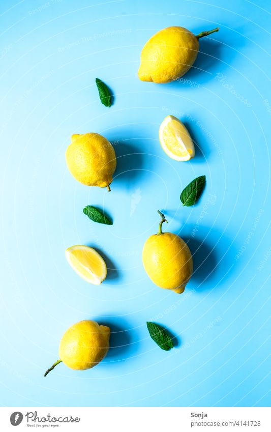 Lemons and peppermint on a blue background. Flat lay. Yellow Mature Blue background flat lay Sour Citrus fruits Juicy Vitamin Tropical naturally Green Organic