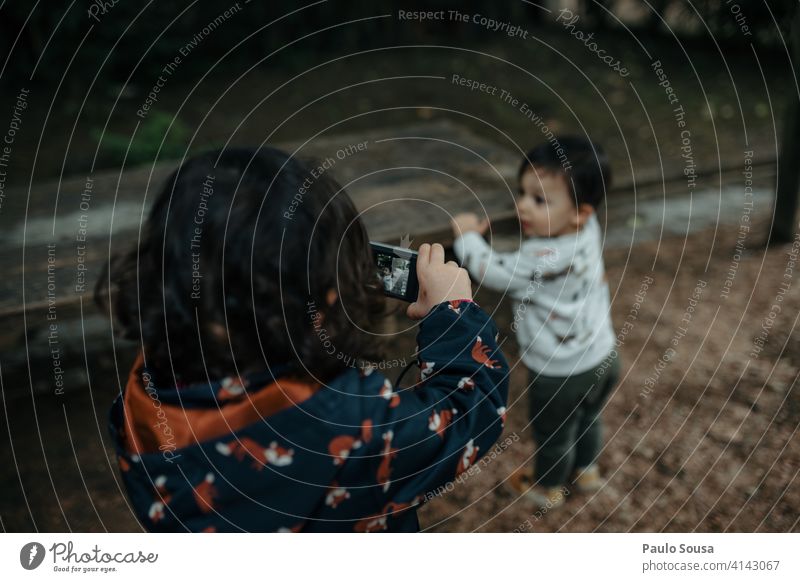 Young girl taking photo of her young brother Brothers and sisters Child 1 - 3 years Caucasian childhood Digital Digital photography Camera Technology Happy