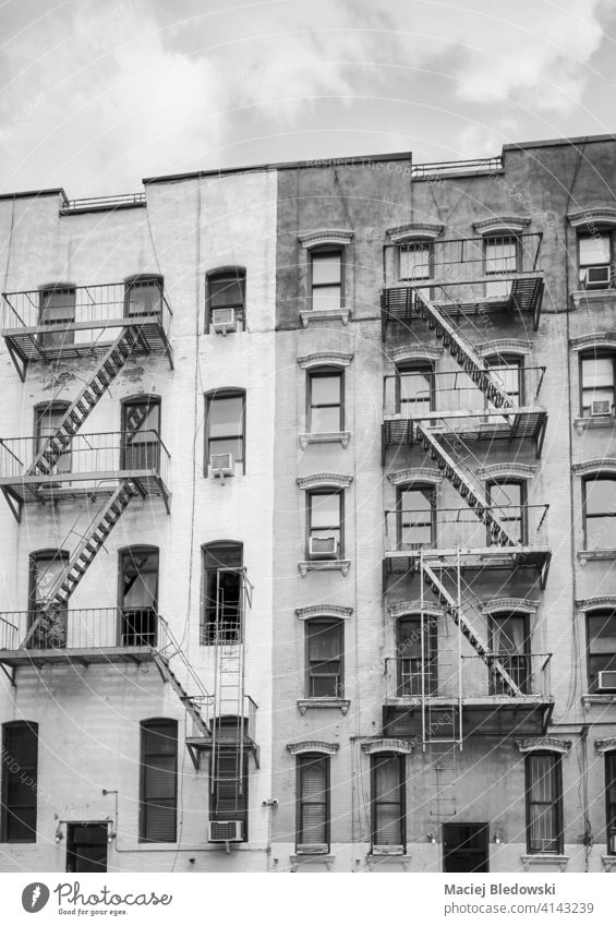 Black and white picture of old buildings with iron fire escapes, New York City, USA. black and white city Manhattan townhouse apartment architecture stairs