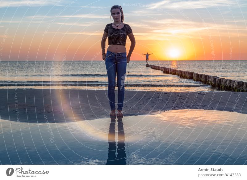 sunset over the baltic sea, portrait of a young woman standing on the beach balancing beautiful beauty boy dusk far freedom girl groin horizon idyllic jetty